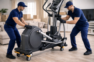 Two men moving exercise equipment indoors.